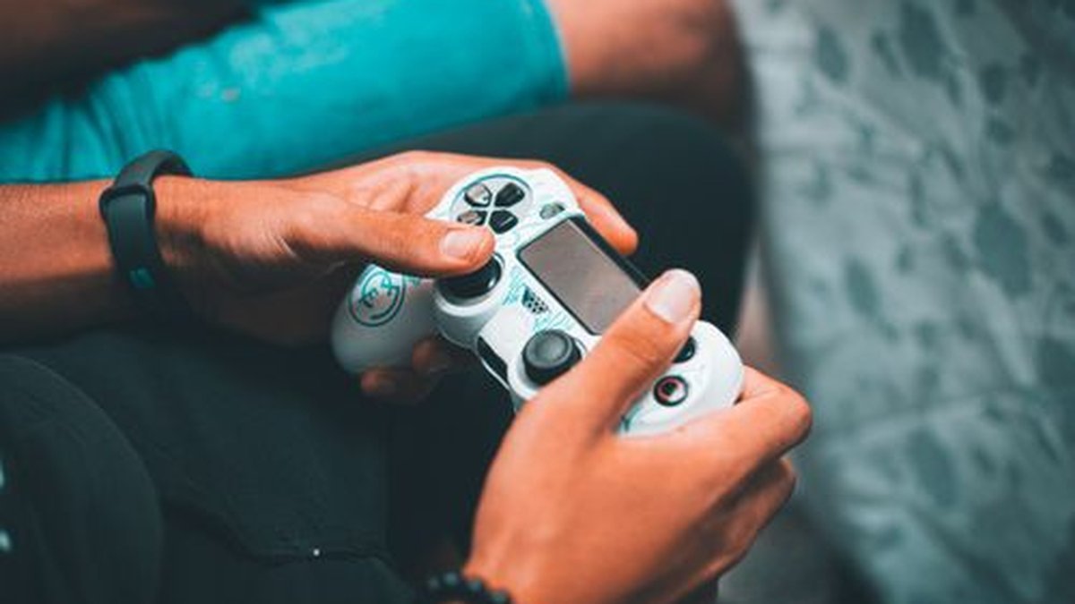 Hands holding a PS5 DualSense controller, one of the best PS5 accessories 2026
