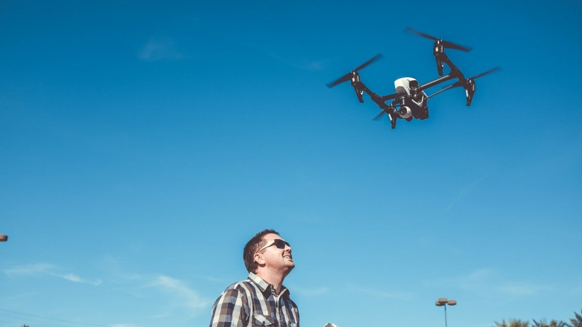 Person flying a sub-249g DJI drone with remote controller in 2026
