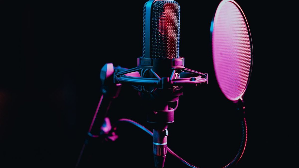 Podcast desk setup featuring one of the best studio microphones for creators on a boom arm